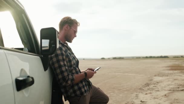 Een Knappe Man Gebruikt Zijn Smartphone Naast Auto Natuur — Stockvideo