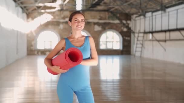 Leende Kvinna Blå Kostym Håller Yogamatta Sportgymnastiksalen — Stockvideo