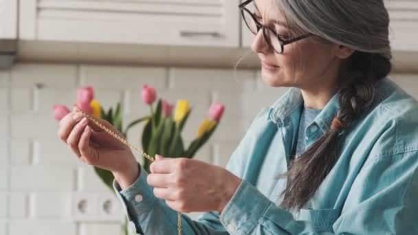 Vacker Fokuserad Äldre Kvinna Gör Handgjorda Smycken Samtidigt Hålla Gyllene — Stockvideo