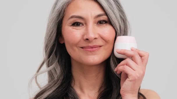 Una Vista Cerca Una Hermosa Anciana Presenta Una Crema Facial — Vídeos de Stock