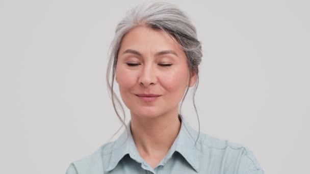 Nærbillede Positiv Ældre Forretningskvinde Blinker Til Kameraet Stående Isoleret Grå – Stock-video
