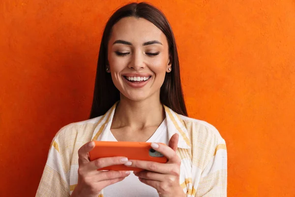 快乐快乐的女人使用灰色背景的手机 — 图库照片