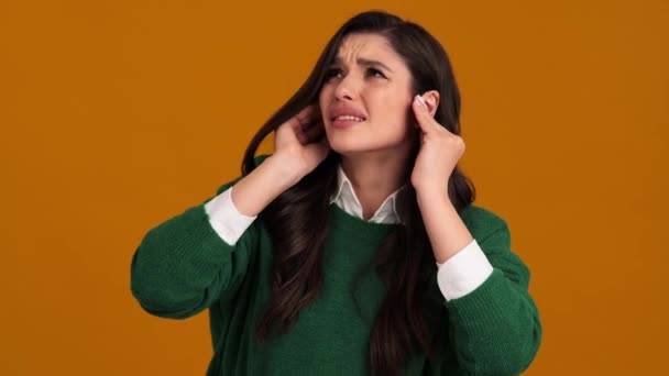 Una Mujer Perdida Suéter Verde Una Camisa Cubriéndose Las Orejas — Vídeo de stock