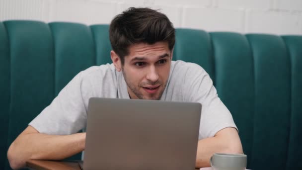 Egy Pólós Fiatalember Meglepetten Nézte Laptopot Kezével Pihentette Fejét Miközben — Stock videók