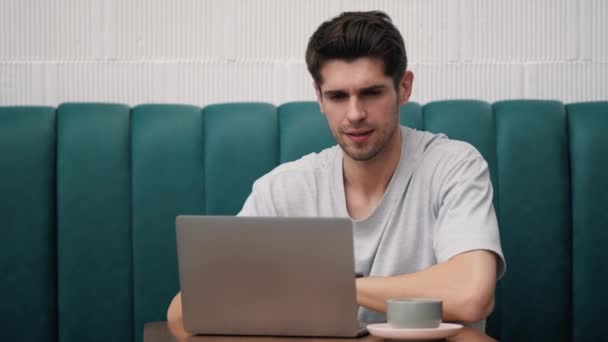Egy Magabiztos Fiatalember Gépel Valamit Laptopon Miközben Egy Kávézóban — Stock videók