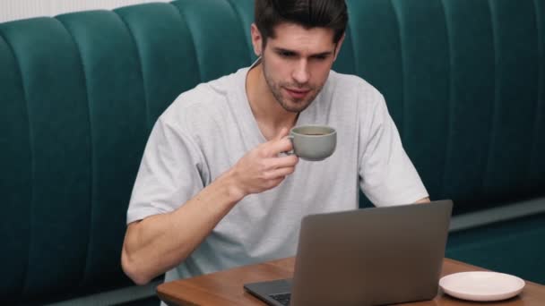 Confident Young Man Drinking Coffee Looking Laptop While Sitting Table — Stock Video