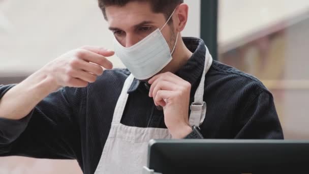 Barista Masculino Ajustando Una Máscara Protectora Desechable Antes Comenzar Turno — Vídeos de Stock