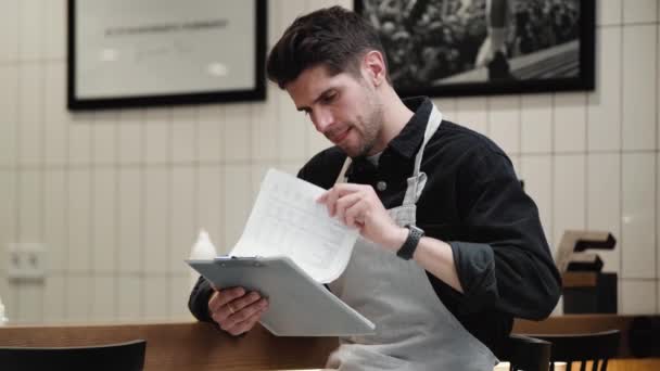 Barista Meditativo Folheando Contas Coçando Cabeça Com Lápis Café — Vídeo de Stock