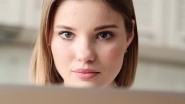 Dairelerin içinde otururken dizüstü bilgisayarını kullanarak çalışan güzel bir kadının yakın çekim görüntüsü.
