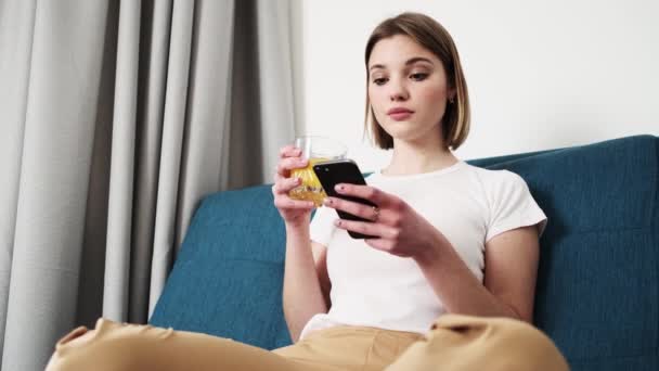 Atraktivní Žena Používá Svůj Smartphone Zatímco Sedí Pohovce Uvnitř Apartmánů — Stock video