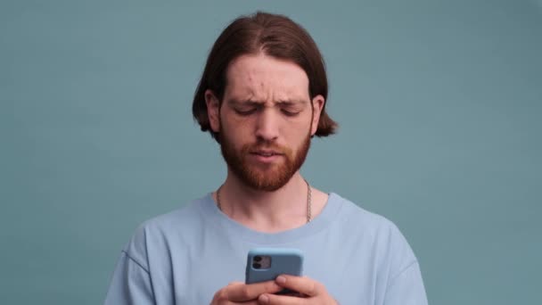 Serious Man Using His Smartphone Standing Isolated Blue Color Background — Stock Video