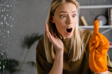 Şok edici Avrupalı kadın eldivenlerini giyip evdeki camlara bakıyor.