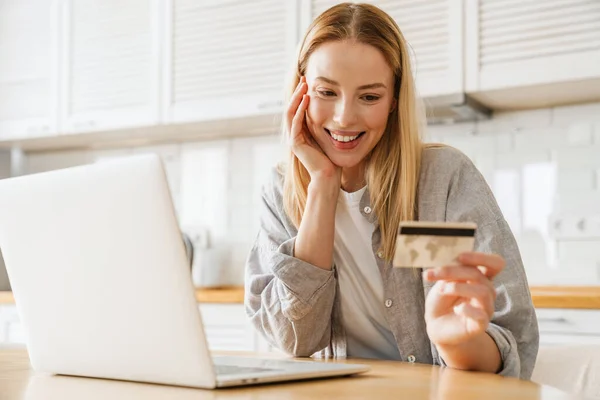 Gadis Pirang Ceria Menggunakan Laptop Dan Kartu Kredit Saat Duduk — Stok Foto