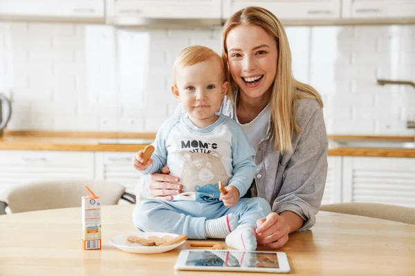 Feliz Hermosa Mujer Usando Tableta Mientras Alimenta Hijo Casa —  Fotos de Stock