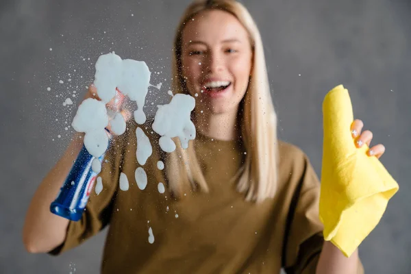 Mulher Loira Feliz Empregada Segurando Garrafa Detergente Pano Pulverizando Vidro — Fotografia de Stock