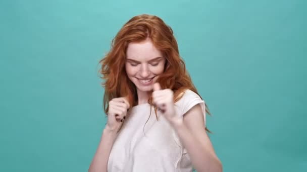 Tişörtlü Gülümseyen Kızıl Kadın Dans Ediyor Turkuaz Arka Planda Kameraya — Stok video