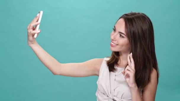 Mulher Morena Feliz Shirt Fazendo Selfie Smartphone Sobre Fundo Turquesa — Vídeo de Stock