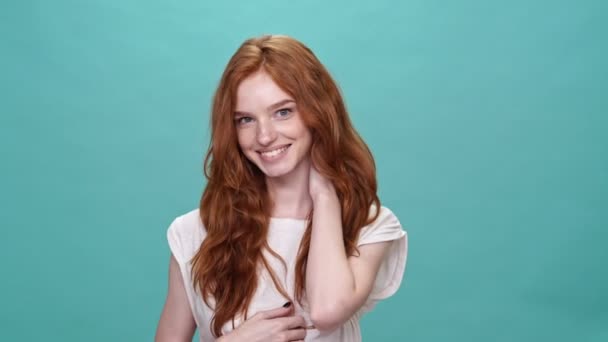 Tişörtlü Gülümseyen Kızıl Kadın Turkuaz Arka Planda Poz Veriyor Kameraya — Stok video