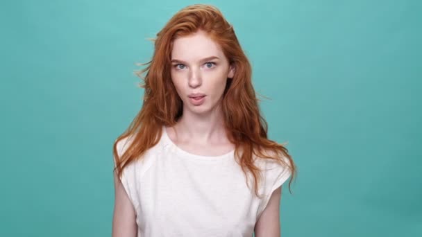Gelukkig Grappig Gember Vrouw Shirt Tonen Grimaces Camera Turquoise Achtergrond — Stockvideo