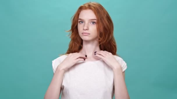 Mooie Gember Vrouw Corrigeert Haar Shirt Kijken Naar Camera Turquoise — Stockvideo