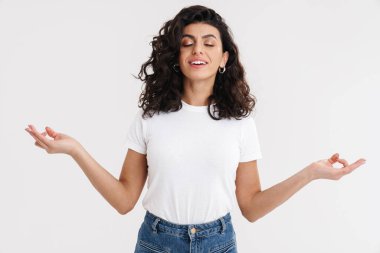 Gülümseyen, sıradan esmer bir kadının portresi. Gözleri kapalı meditasyon yapan, beyaz arka planda izole edilmiş.