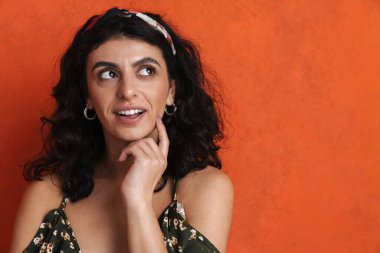 Beyaz arka planda izole edilmiş bir şeyi düşünen sıradan, güzel, genç bir kızın yakın plan portresi.