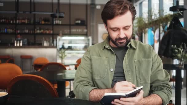 Hombre Guapo Está Escribiendo Algo Sentado Café — Vídeos de Stock