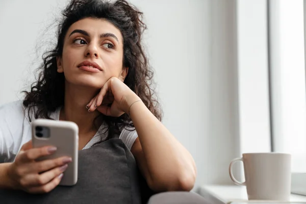 Focada Morena Jovem Usando Telefone Celular Enquanto Sentado Sofá Casa — Fotografia de Stock