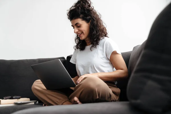 Gelukkig Brunette Jong Vrouw Werken Met Laptop Terwijl Zitten Bank — Stockfoto