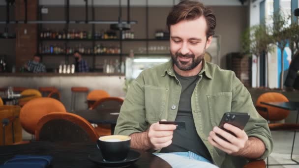 Hombre Satisfecho Está Usando Teléfono Inteligente Tarjeta Crédito Mientras Transfiere — Vídeo de stock