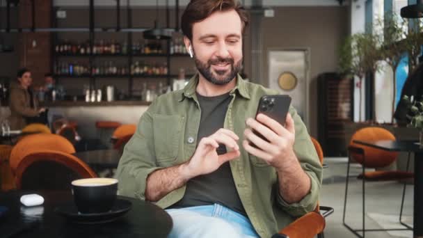 Homem Positivo Está Falando Com Conexão Vídeo Enquanto Bebe Café — Vídeo de Stock