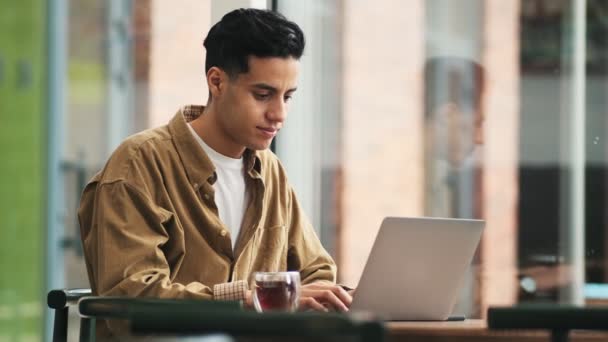 Hombre Árabe Guapo Está Trabajando Con Portátil Mientras Bebe Café — Vídeos de Stock