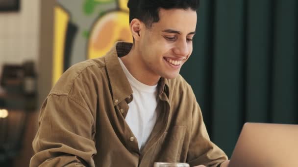 Egy Boldog Arab Férfi Dolgozik Laptopjával Miközben Kávét Iszik Kávézóban — Stock videók