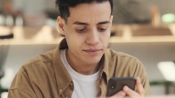 Homem Árabe Concentrado Está Usando Seu Smartphone Sentado Café Moderno — Vídeo de Stock