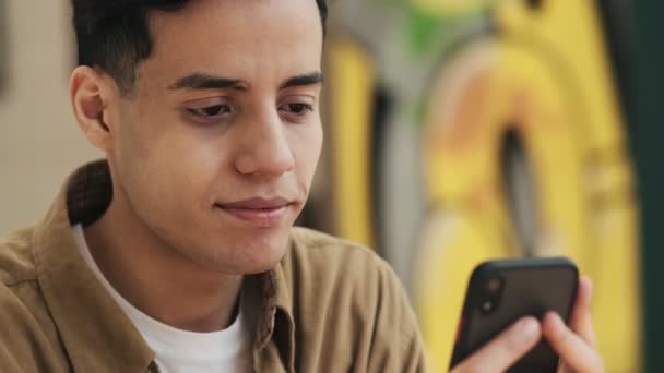 Een Tevreden Arabier Gebruikt Zijn Smartphone Zittend Het Moderne Café — Stockvideo