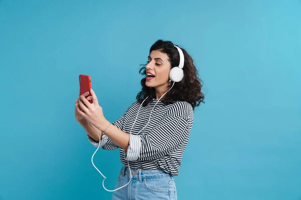 Portrait Happy Woman Listening Music Headphones Isolated Blue Background Holding — Stock Photo, Image