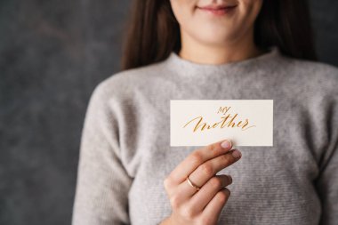 Kafkasyalı memnun kız içeride kameraya anne kartımı gösteriyor.