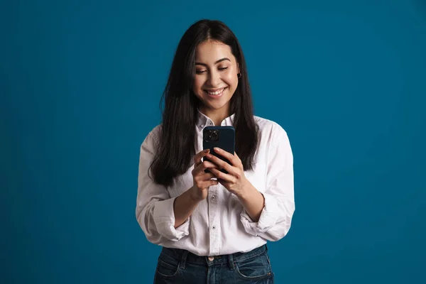 행복하고 아름다운 소녀가 웃으면서 고립된 스마트폰을 사용하는 — 스톡 사진