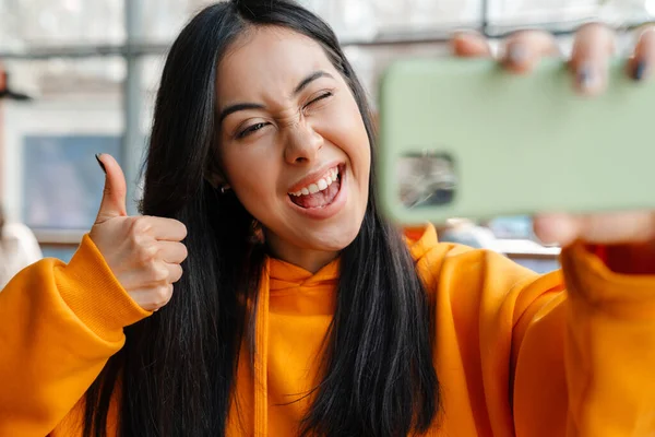 Uśmiechnięta Azjatycka Kobieta Gestykulując Kciuk Górę Podczas Robienia Selfie Komórkę — Zdjęcie stockowe
