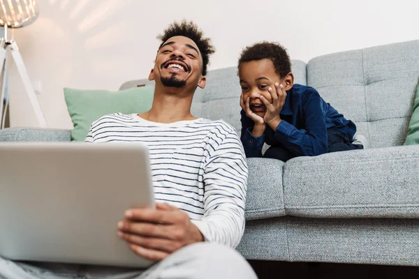 Feliz Afroamericano Padre Hijo Sonriendo Usando Ordenador Portátil Mientras Está —  Fotos de Stock