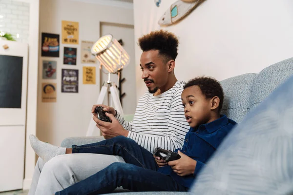 Enfocado Afroamericano Padre Hijo Jugando Videojuego Mientras Está Sentado Sofá —  Fotos de Stock