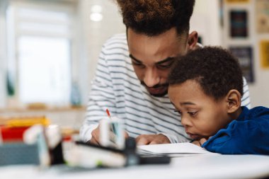 Ciddi bir Afro-Amerikan babası. Odaklanmış oğluyla ev ödevi yapıyor.