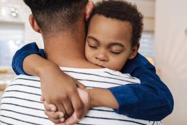 Baba, oğlunu mutfakta taşırken yakın çekim.
