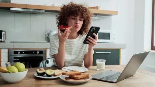 Una Chica Pelo Rizado Mirando Teléfono Desayunando Cocina — Vídeo de stock
