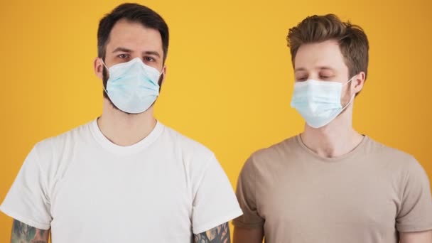 Deux Beaux Gars Portant Des Masques Médicaux Protecteurs Saluent Tout — Video