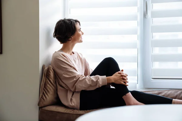 Glad Vacker Flicka Ler Medan Sitter Fönsterbrädan Hemma — Stockfoto