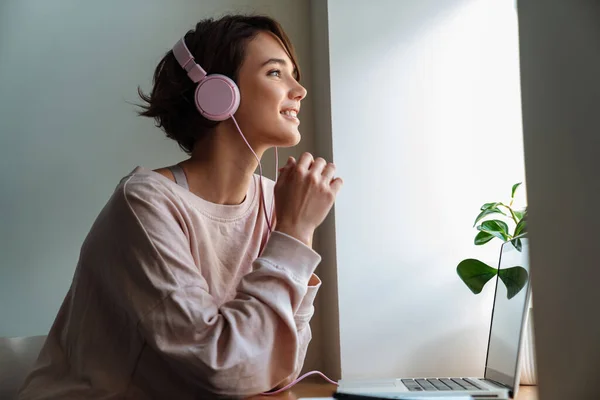 Glückliche Schöne Mädchen Mit Kopfhörern Arbeiten Mit Laptop Fenster Drinnen — Stockfoto