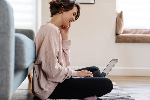 Menina Bonita Alegre Trabalhando Com Laptop Enquanto Sentado Chão Casa — Fotografia de Stock