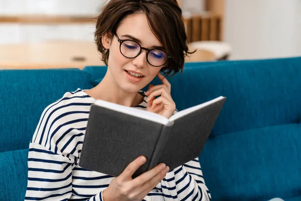 Gelukkig Jong Vrouw Lezen Boek Bank Thuis — Stockfoto