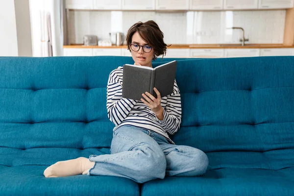 Glückliche Junge Frau Liest Buch Hause Auf Der Couch — Stockfoto